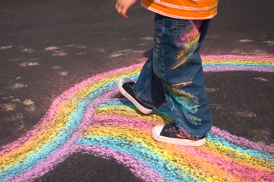 Child walking over a chalk rainbow - improving children's challenging behaviour