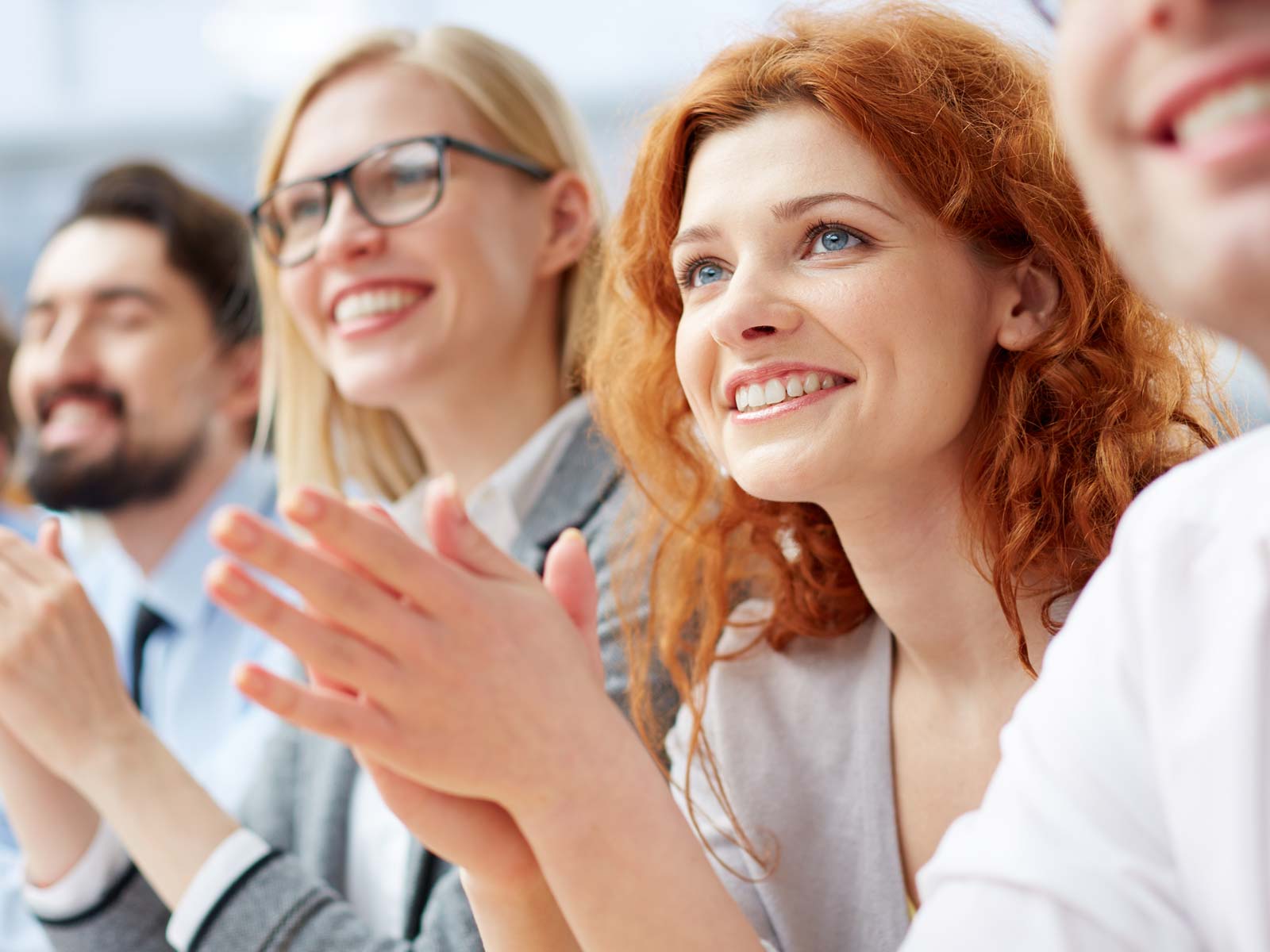 A group of adults smiling and clapping