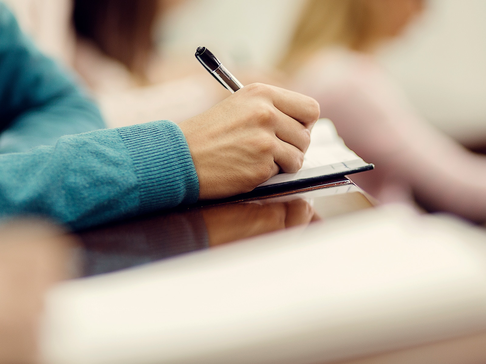 Adult writing in a book - human givens foundation