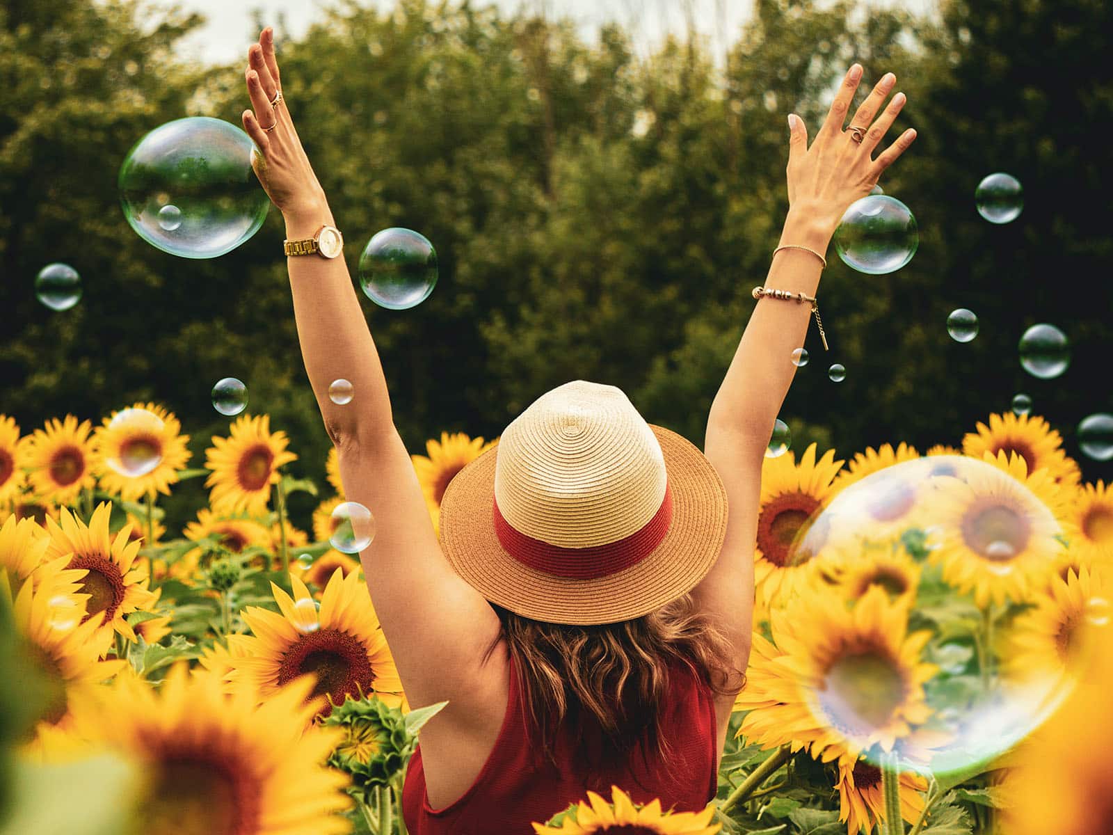 Woman in a sunflower field with bubbles everywhere