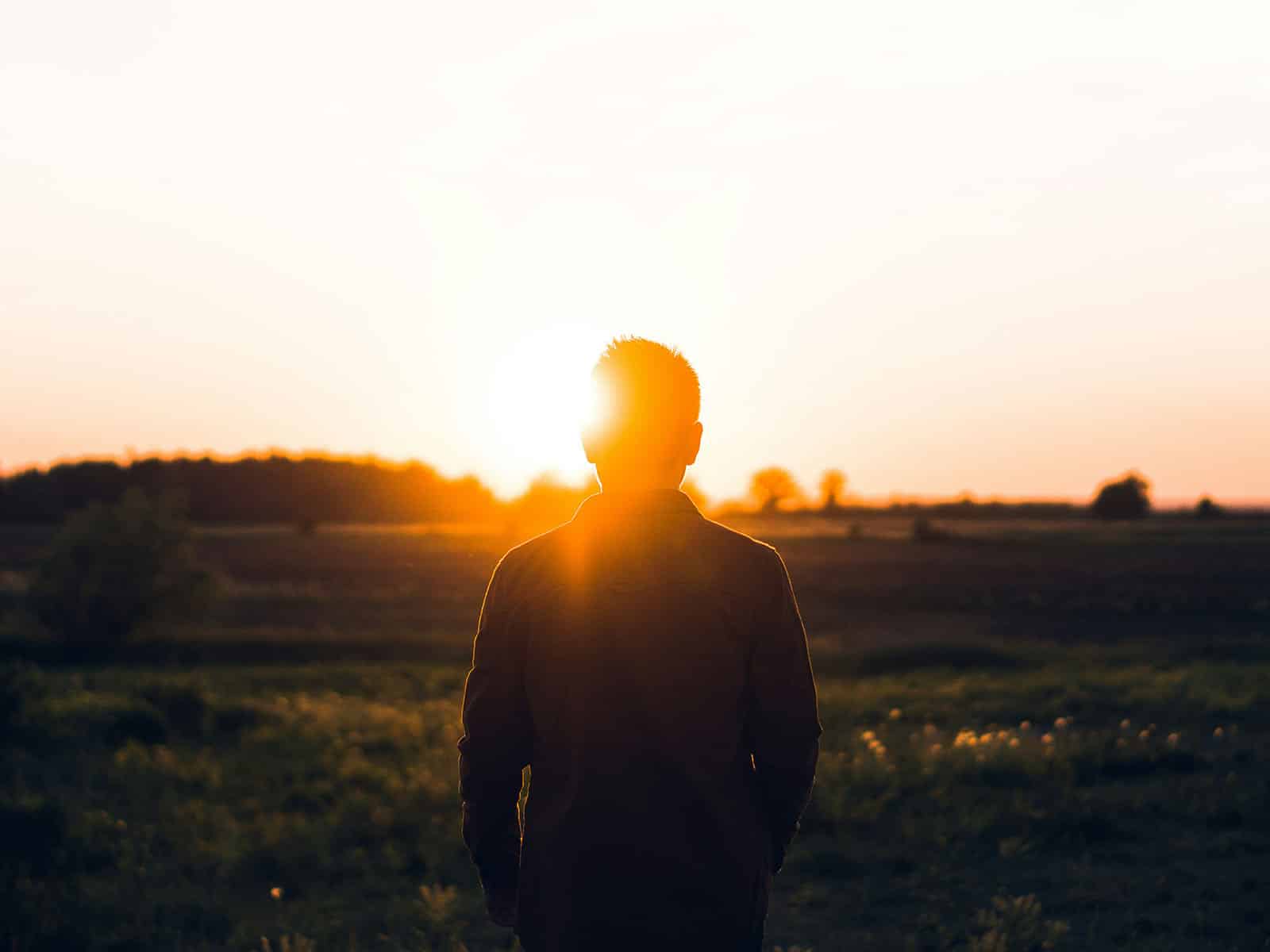 sun backlit portrait of man shot from behind